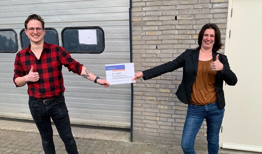 <p>Ruben Kuiper (Jeugdspeelweek) en Tinka Pieterse (Scouting) voor de loods die beide organisaties samen zullen gebruiken als opslagplaats. </p>