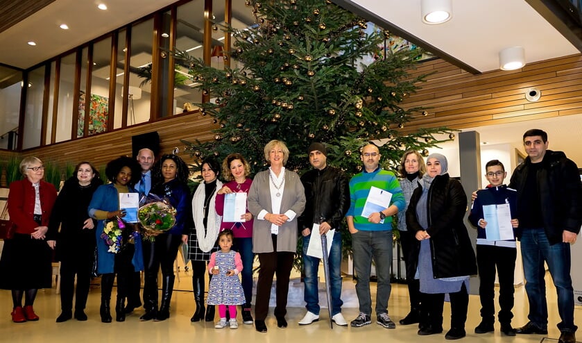 Een deel van de nieuwe Nederlanders met burgemeester Driessen (midden) en wethouder McDaniel (4e van rechts). | Foto: J.P. Kranenburg