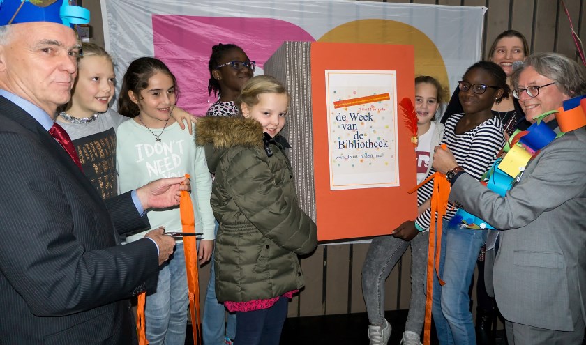 Wethouder Jeff Gardeniers (geheel links) en directeur Willem van Moort van BplusC (geheel rechts) openen samen met enkele jonge lezers de Week van de Bibliotheek. | Foto: J.P. Kranenburg