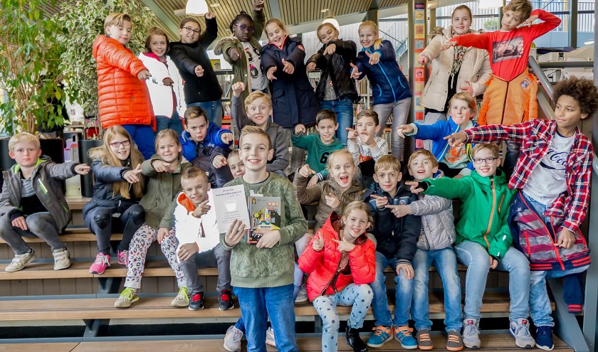 Luca met zijn boek en oorkonde. Op de achtergrond zijn klasgenootjes, die vrijdag allemaal in de Leiderdorpse bibliotheek boeken kwamen uitzoeken. | Foto: J.P. Kranenburg