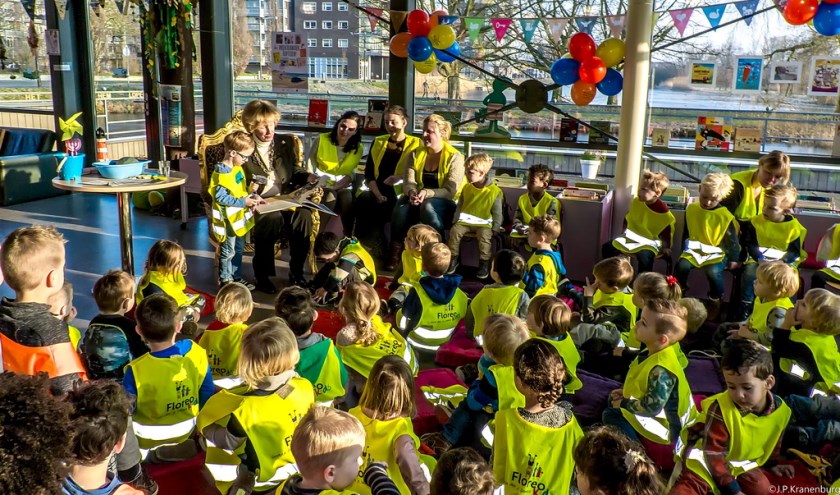 De peuters hangen aan de lippen van burgemeester Driessen die 'De kleine walvis' voorleest. | Foto: J.P, Kranenburg