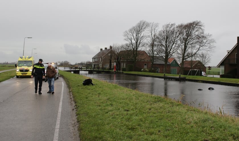 Twee wielen van de sportwagen steken nog net boven het water uit.