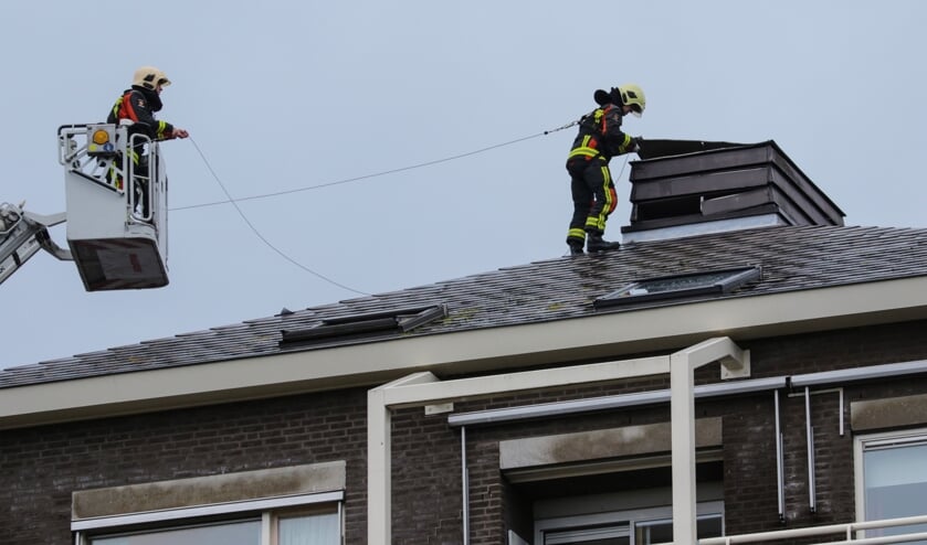 Brandweerlieden proberen de loszittende platen weer vast te krijgen. Foto: AS Media