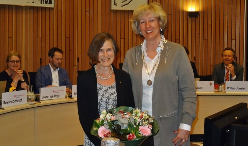 Esta Hoogervorst werd door burgemeester Driessen in het zonnetje gezet. Op de achtergrond leden van de gemeenteraad. | Foto: C. v.d. Laan