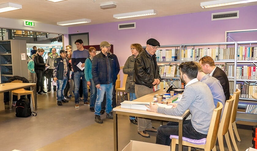 Een rij van kiezers wacht op hun beurt bij het stembureau in de bibilotheek in De Sterrentuin.