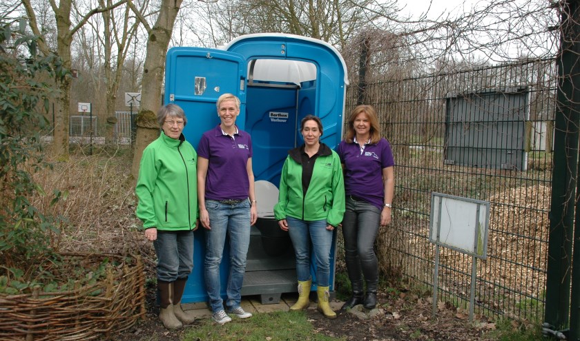 V.l.n.r. Riny Vons (voorzitter natuurspeeltuin), Ilse van Kesteren (BEC), Linda Visser (secretaris natuurspeeltuin) en Karin Anthonissen (BEC) bij het mobiele toilet in de natuurspeeltuin.