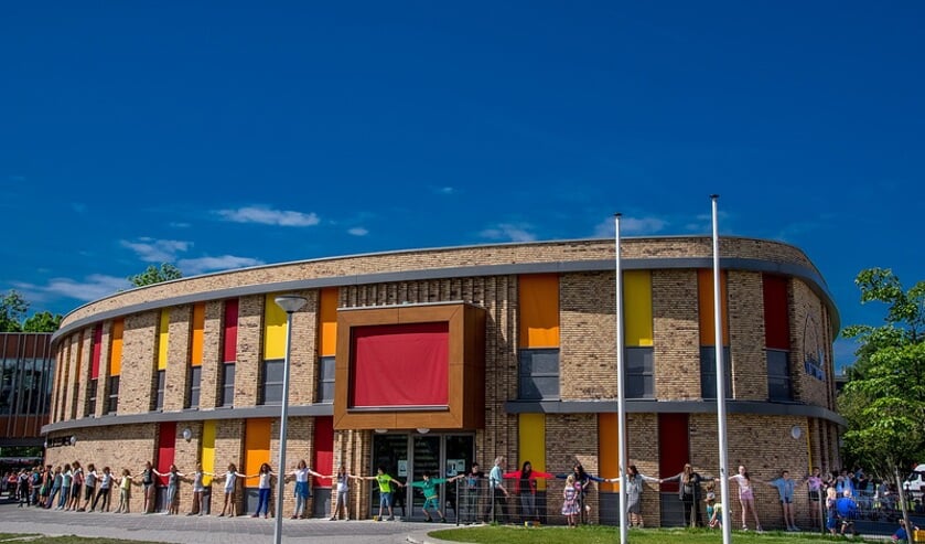 De leerlingen vormen een lang lint rond de school aan de Leeuweriklaan. | Foto: J.P. Kranenburg