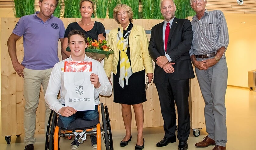 Jeroen Op de voorgrond Jeroen Kampscheur met een tas vol gemeentelijke cadeaus. Achter hem v.l.n.r. zijn ouders Eric en Yvette, burgemeester Driessen, wethouder McDaniel en Jeroen's opa Piet van Leeuwen.