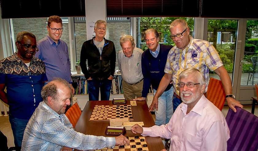 Leden van de Leiderdorpse Damclub zien hoe Paul Lovink (links) trapt in de geniepige Groenzet van Reginald Lindemans. Verder van links nar rechts: Glenn Hardenberg, AlexZwanenburg, Jan Dekker, Martend van der Vecht en Cees Zwanenburg. Niet op foto (vakantie): Cora Koopman en Peter Slingerland.