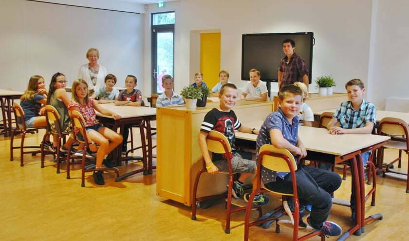 Groep 8 van de Regenboog in de fonkelnieuwe aula. Linksachteraan staat locatieleider Carla Kerner.