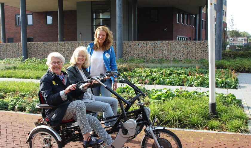 Annechien Snuif krijgt uitleg van een andere duofiets-vrijwilliger. Ada Seijsener (l) geniet volop.