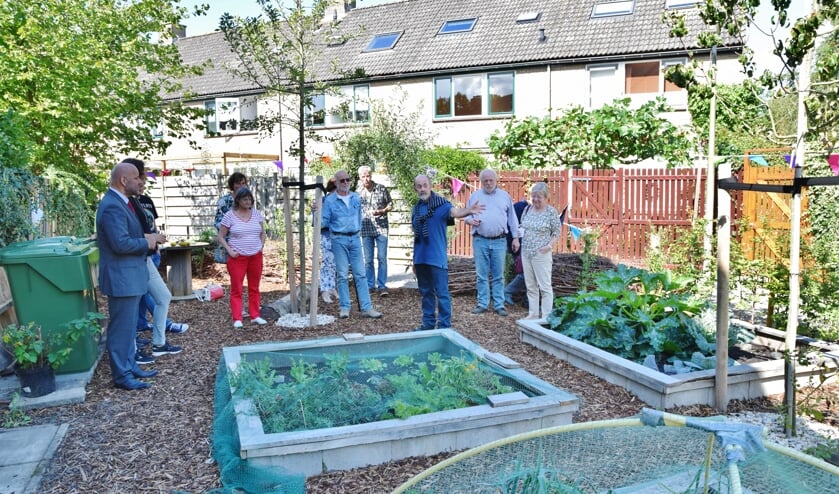 Wethouder Olaf McDaniel (geheel links) krijgt uitleg over de buurtmoestuin van buurtvereniging De Kruidentuin.