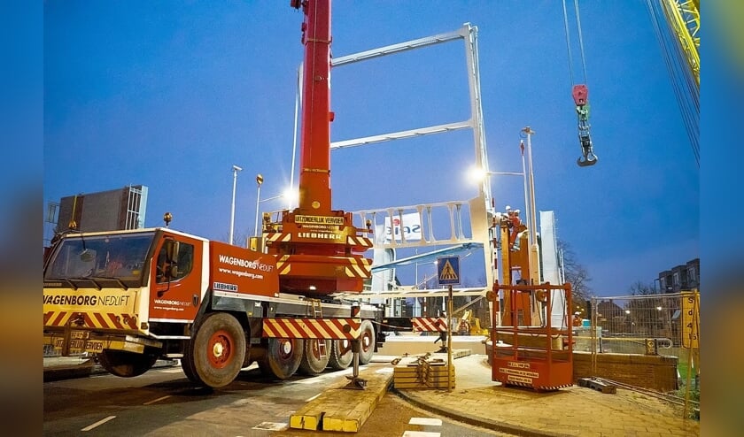 De balans van de brug wordt op zijn plek getakeld.