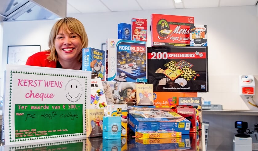 Adinda Dernison met een deel van de nieuwe spellen. Links de cheque die de Vrienden van het Oude Dorp vlak voor kerst uitreikten.