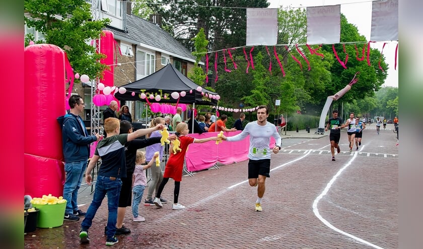 Kinderen staan klaar met sponzen voor de lopers op de Splinterlaan.