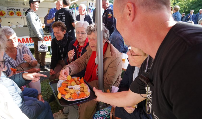 Bestuurslid Christ Kreugel van de Vrienden van het Oude Dorp trakteert de vrijwilligers op lekkere snacks.