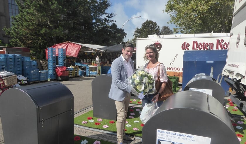 Wethouder Dennis Salman overhandigt een boeket aan de eerste gebruiker van het milieupark op het Kloosterplein. | Foto: Ina Verblaauw