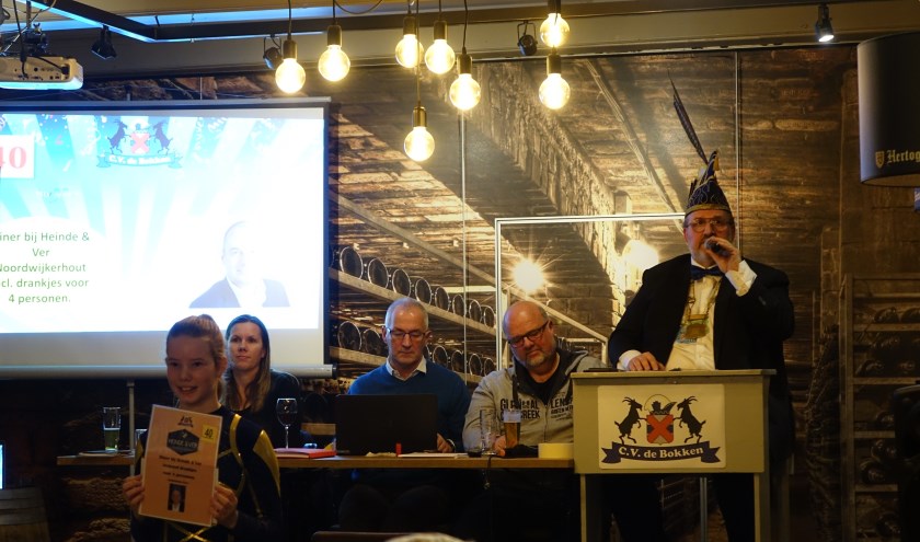 Voorzitter Theo van Werkhoven, voor de gelegenheid ook veilingmeester, veilt een van de 200 kavels.