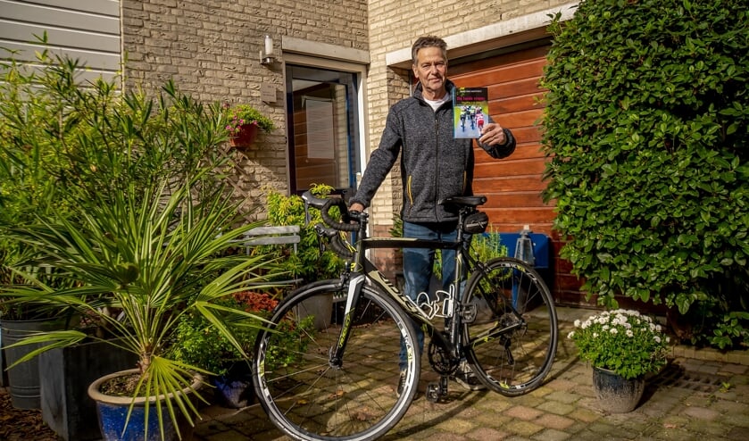 Hans van Hartevelt met de fiets waarop hij vele kilometers aflegt en zijn nieuwste boek. | Foto: J.P. Kranenburg
