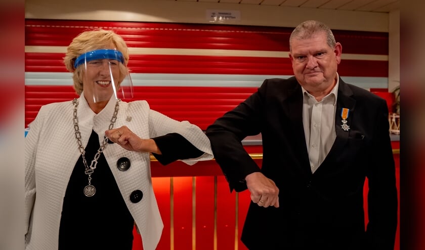 <p>Burgemeester Driessen feliciteert Rob Blauw nadat ze hem coronaproof het lintje heeft opgespeld. </p>