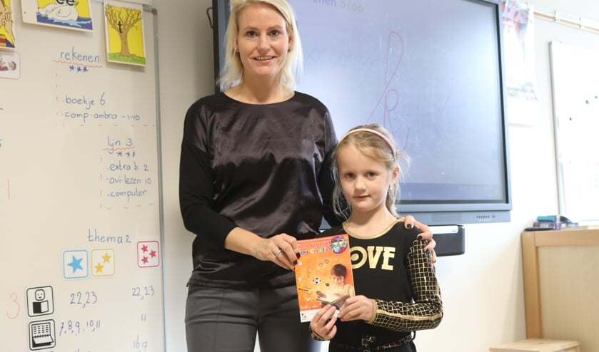 <p>Wethouder Jeanet van der Laan overhandigde bij de Josephschool de eerste boekjes aan leerlingen. | Foto: pr</p>