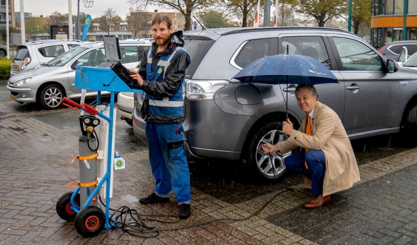 <p>Wethouder Willem Joosten (met paraplu) kwam zaterdagmiddag een kijkje nemen bij de actie 'Band op spanning' en liet meteen zijn banden controleren. </p>
