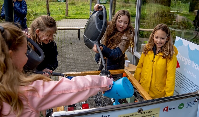 Kinderen laten het regenen in de speelstad.