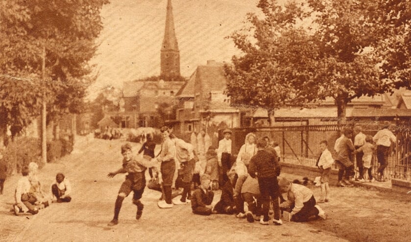 De Herenstraat met spelende kinderen voor de katholieke jongensschool omstreeks 1929.