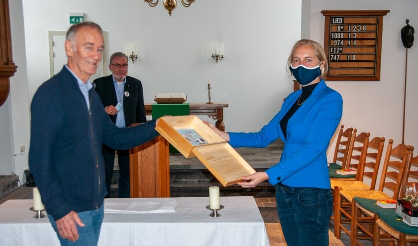 <p>Onder toeziend oog van Jos van de Burg overhandigt Leon Floor de cheque aan dominee Esmeralda Mandemaker. | Foto: Ans Geerlings.</p>