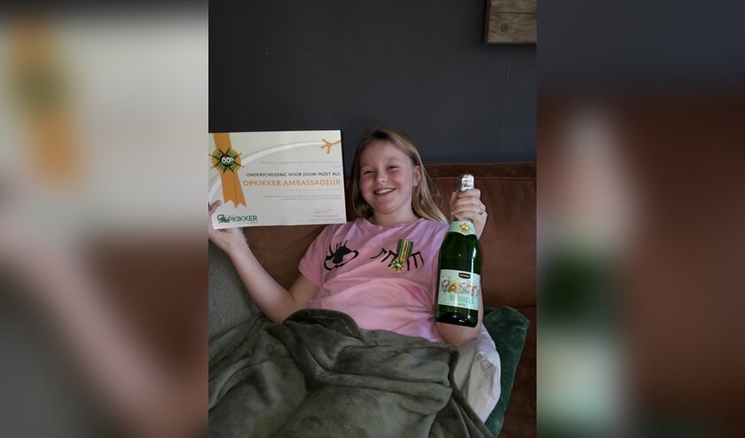 Opkikker ambassadeur Rosalie Sloos met haar onderscheiding en een feestelijke fles. | Foto: PR