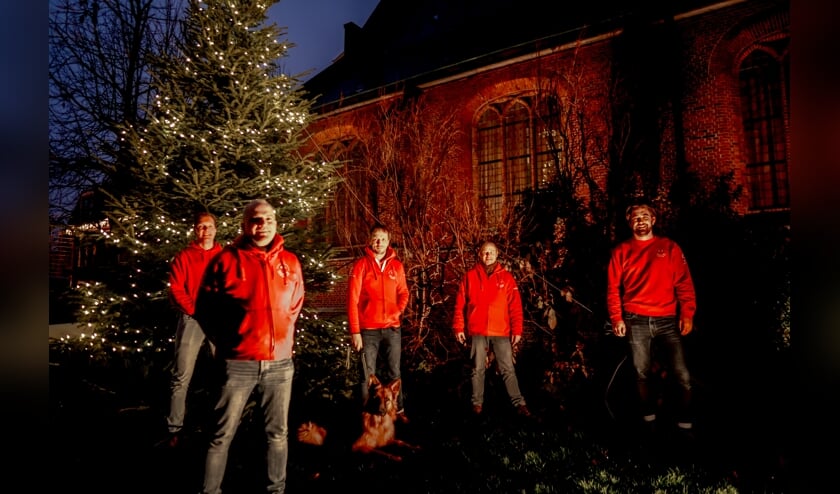 <p>Voorzitter Herbert Zilverentant (linksvooraan) en vier bestuursleden van de Vrienden van het Oude Dorp bij de verlichte kerstboom. </p>