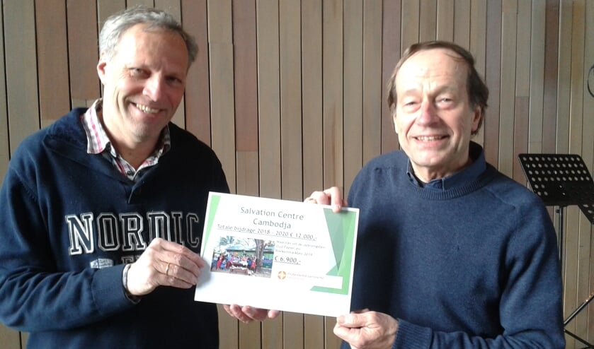 Werelddiakenen Jan van der Wel en Cor van Viegen lieten twee weken geleden, toen het ernaar uit ging zien dat de overhandiging in de Dorpskerk niet door kon gaan, de cheque zien.