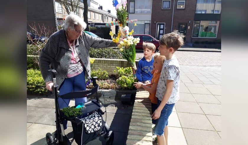 Kinderen brengen hun palmpasenstokken naar de oudere inwoners. | Foto: pr.