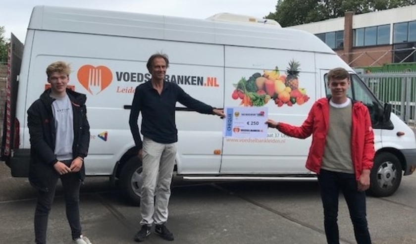 De coaches van Alecto JB1 overhandigden de cheque van 250 euro aan een vertegenwoordiger van de Voedselbank Leiden.