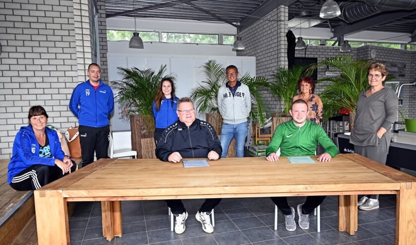 De nieuwe trainers Rob Berreboom (links aan tafel) en Dennis van der Horst (rechts) bij de contractondertekening.