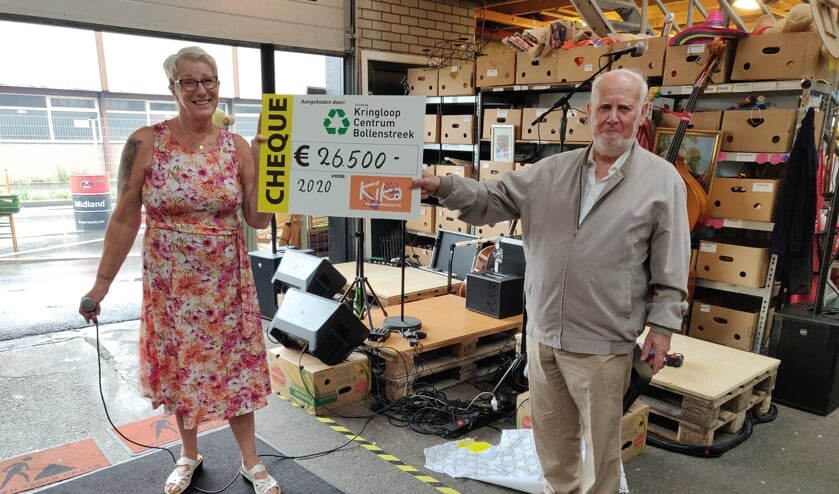 Bedrijfsleidster Cathy en vrijwilliger Quirinus onthullen het bedrag voor KiKa.