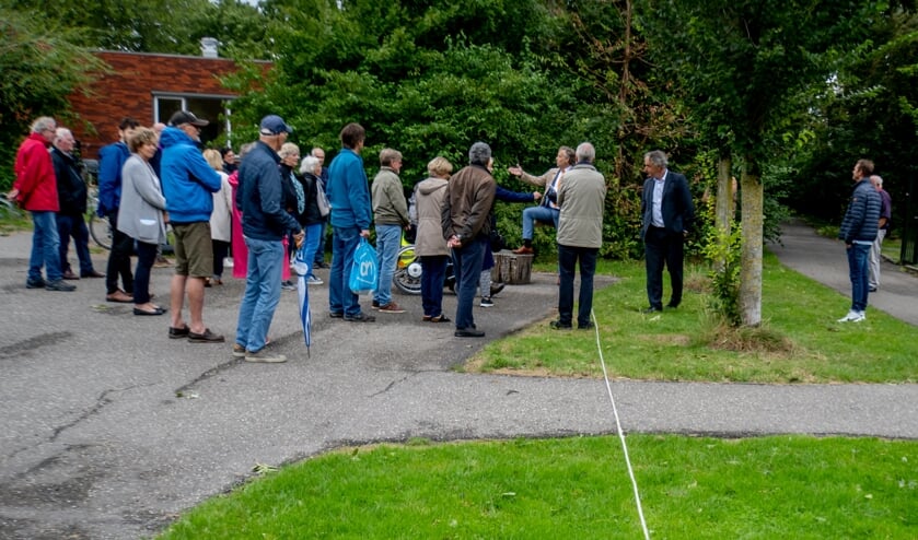 Joosten (5e van rechts) praat met bewoners. Het touw op de grond laat zien hoe breed een doorfietspad zou worden.