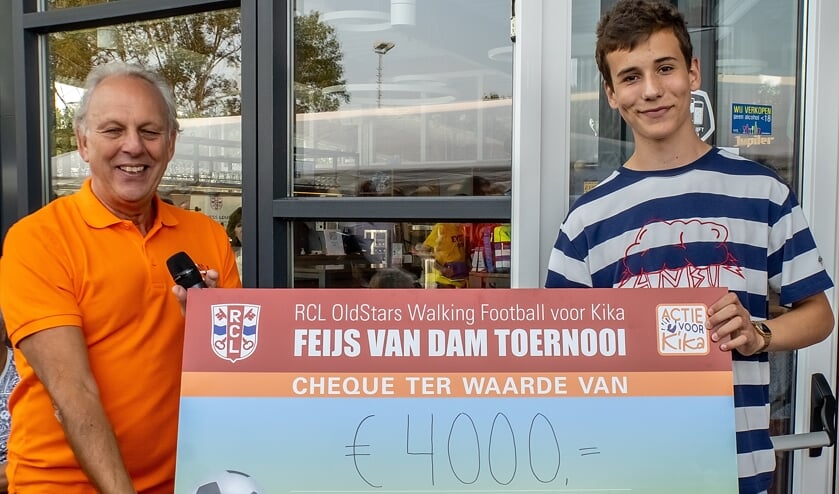 Feijs van Dam overhandigt de toernooiopbrengst aan een vertegenwoordiger van KiKa.