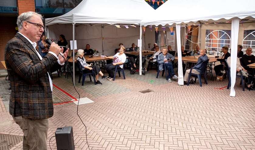 Directeur-bestuurder Chrétien Mommers van Rijnhart Wonen feliciteert zijn huurders met het 20-jarig jubileum van de Brandwacht.