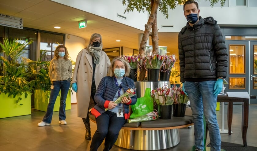 Linda Bezuijen (met beige jas) en Sjoerd Verbree van Vegro overhandigden de tulpen aan medewerkers van De Ommedijk. | Foto: J.P. Kranenburg