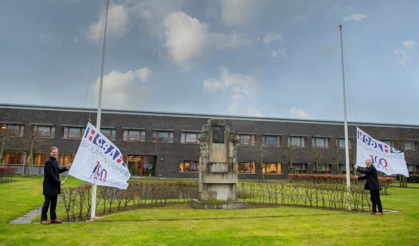<p>De directie hijst de jubileumvlag bij het pand aan de Prof. van Slogterenweg. Links Foeke Gardenier en rechts Sam van Egmond.</p>