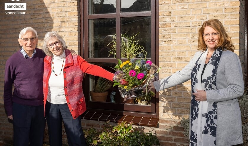 <p>Burgemeester Breuer overhandigt een bloemetje aan het echtpaar Schouten. </p>