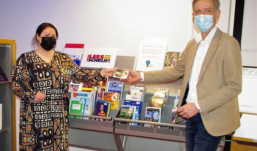 <p>Sarine Alders (Taalhuis), reikt de eerste Wandelwaaier uit aan wethouder Matthijs Huizing. |</p>