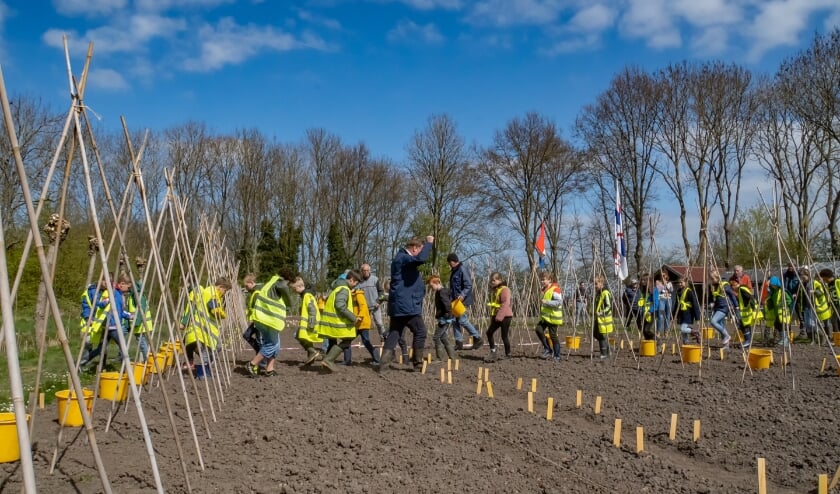 <p>Wethouder Rik van Woudenberg gaat groep 6 van de Willem de Zwijgerschool voor bij het paadjestrappen. De tuintje zijn niet helemaal leeg; vrijwilligers hebben in de afgelopen weken in alle tuintjes alvast aardappelen gepoot, bonenstokken neergezet en bonen geplant.</p>