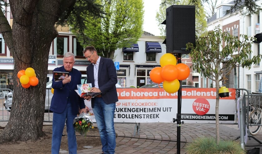Harry Mens krijgt het eerste exemplaar uit handen van Rotary-lid Kees Hogervorst.