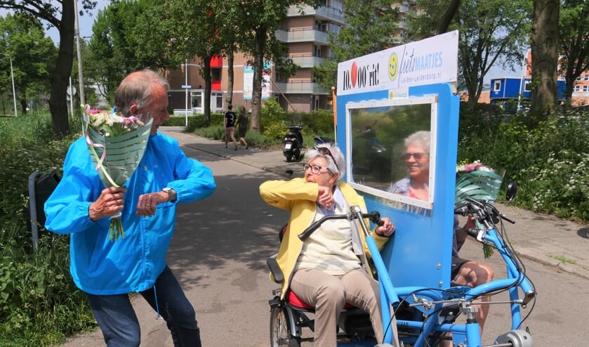 <p>Fietsmaatjes voorzitter Ben Crul overhandigt de bloemen aan Pieta Liefers, vrijwilliger Elly Meijer kijkt toe. | Foto: Carla Kramer</p>